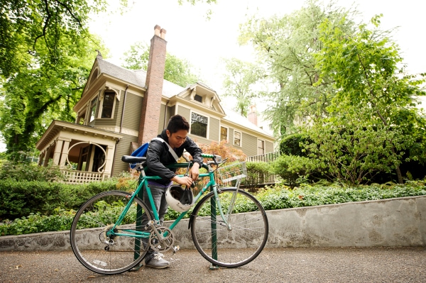 A student securing a bicycle outside the Simon Benson House
